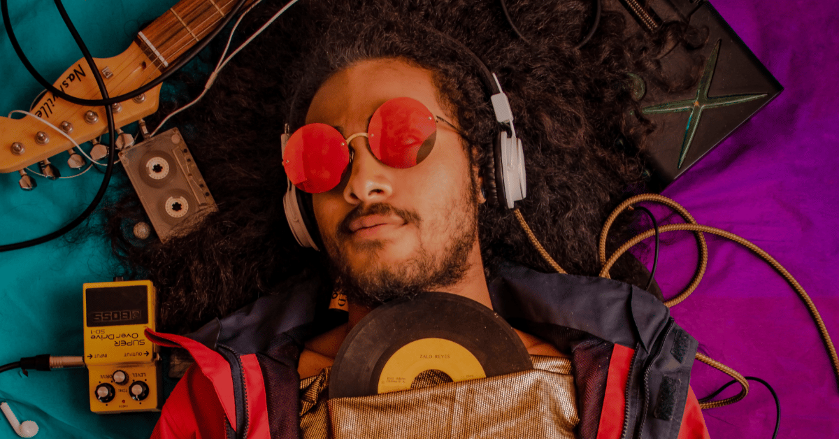 musician using red glasses holding a vinyl disc