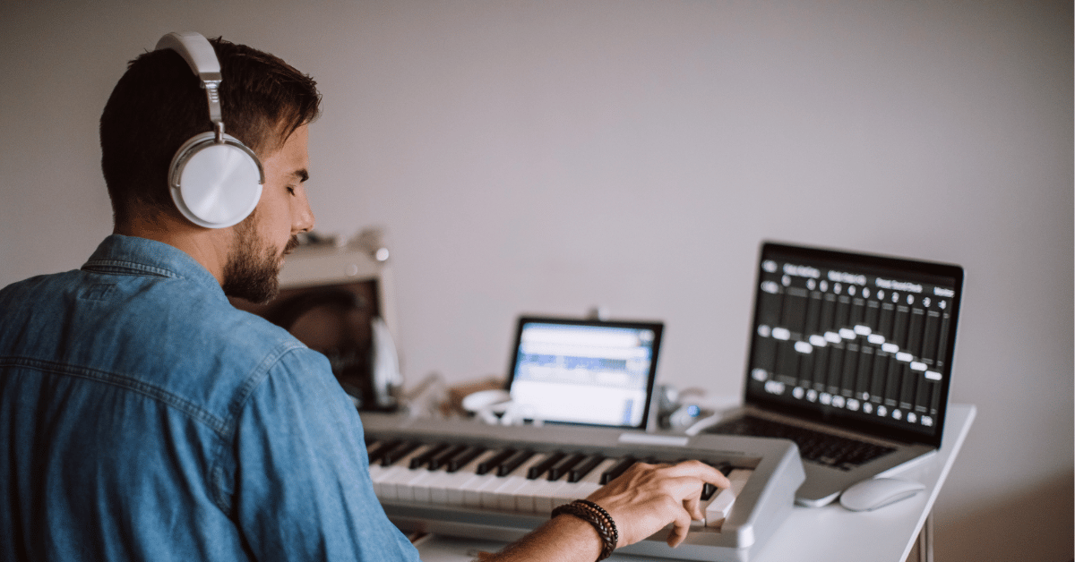 young man playing piano and recording using his laptop