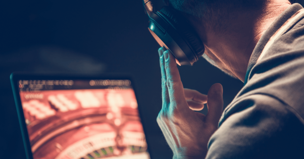 male listening carefully to music in front of his laptop