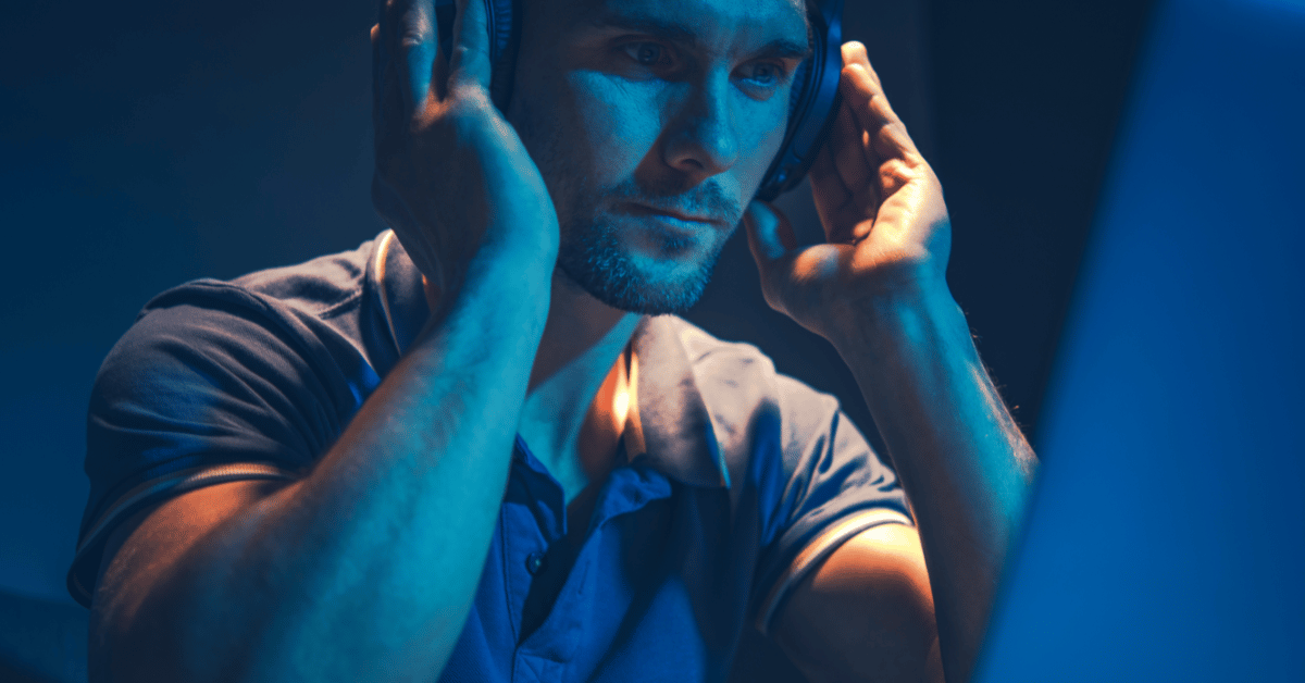 male holding his headphone and listening to music very concentrated