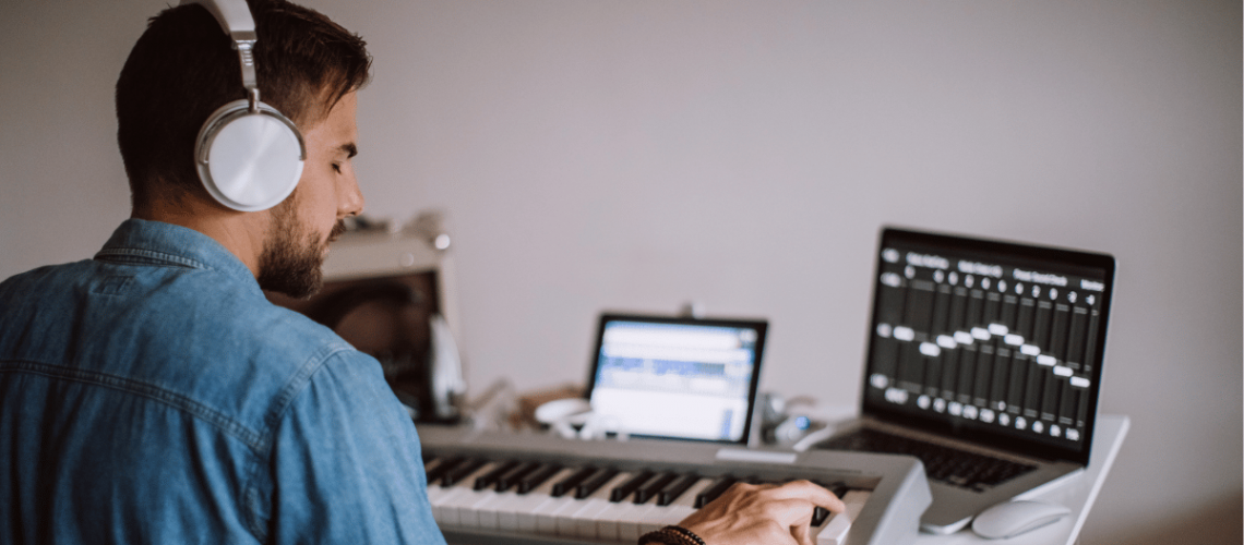 young man playing piano and recording using his laptop