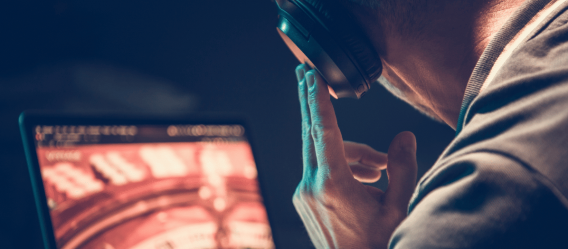 male listening carefully to music in front of his laptop