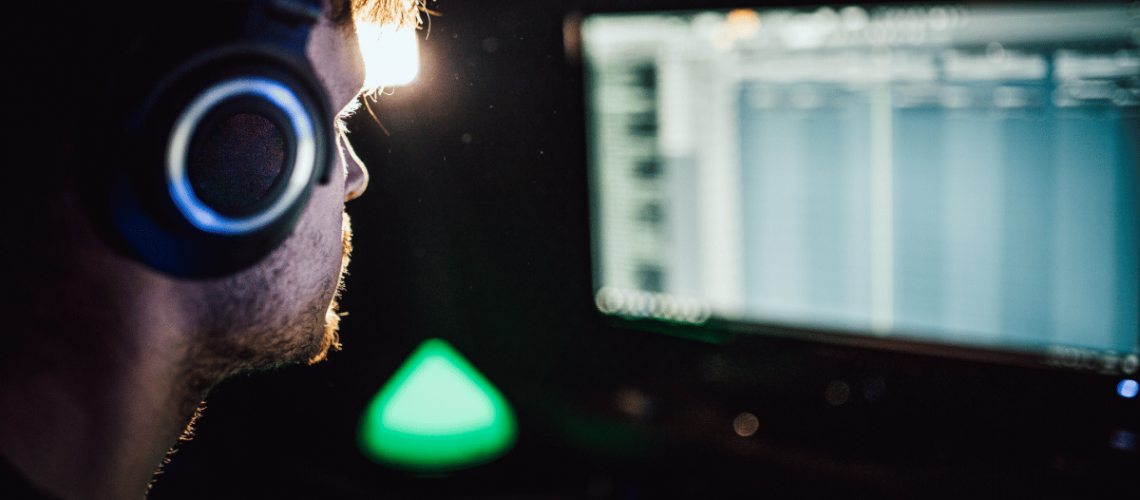 young male wearing headset working on his sound effects for a film